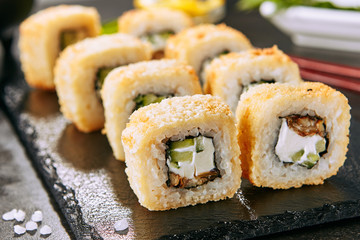 UnagTempura Uramaki Sushi Rolls with Eel on Black Background