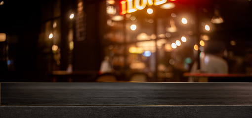 Empty real wood table top with light reflection on scene at restaurant, pub or bar at night.