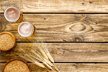 Beer ingredients. Barley near beer glasses on rustic wooden background top view copy space
