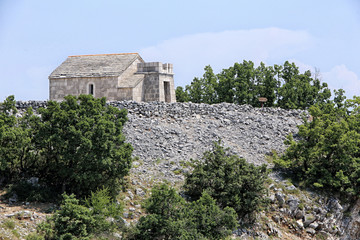 Fototapeta na wymiar Small stony Romanic chapelle on the peak of mountain