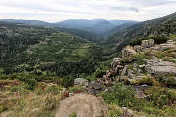 Krkonose deep valley with stony waterfall on side