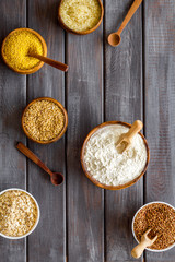 Healthy food concept. Cereals in bowls on dark wooden background top view