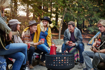 Group of friends camping around fire