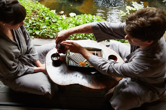 Man pouring tea for woman at Japanese Spa