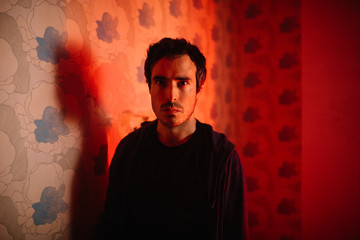 Angry man defiant to camera indoors