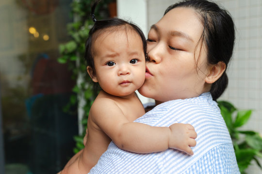 Asian mother with her baby girl in home