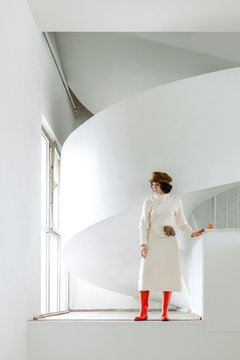 Elegant woman in gumboots standing white hall