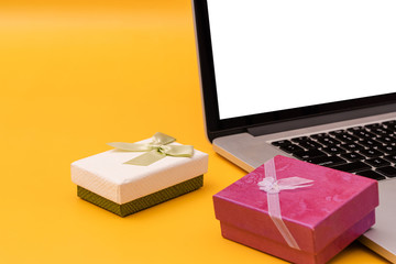 Laptop and gift box on yellow background