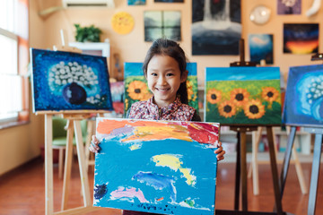 Cute girl taking photos with her art work in class