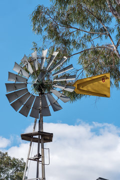 Old windmill on farm against blue summer skies