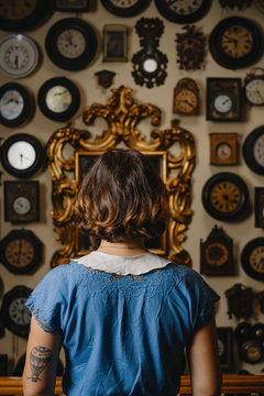 Portrait Of Stylish Girl Wearing Vintage Dress In Front Of The Wall With Clocks