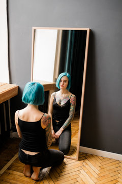 Young Tattooed Woman Near The Mirror