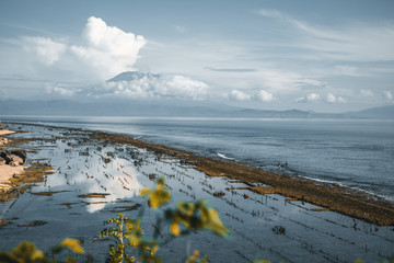 indonesian fishing farm beside the shore with mount agung in the back