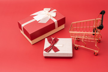 Shopping cart model with a gift box on a red background