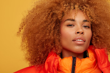 Beautiful woman looking at camera in red orange jacket