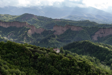 Fototapeta premium The Medieval Orthodox Monastery of Rozhen and Rozhen pyramids -a unique pyramid shaped mountains cliffs in Bulgaria, near Melnik town.