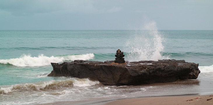 Wave hitting a rock. Cangu Batu bolong beach in Bali, a popular place for a surfer