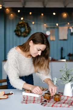 Young woman with homemade salty caramel near Christmas gingerbread