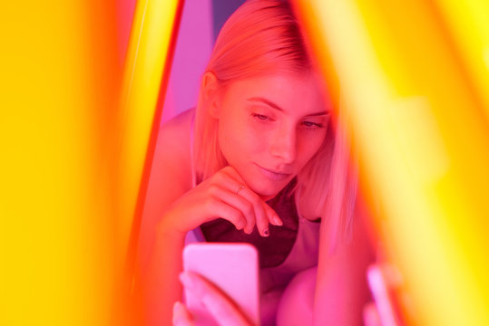 Woman taking selfie in vivid lamp light