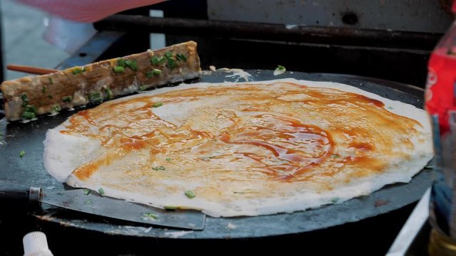 Traditional Jian Bing Being Grilled And Wrapped On Street Food. Fast Food And Cooking Concept