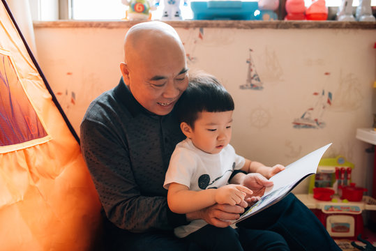 Grandpa reading books with grandson