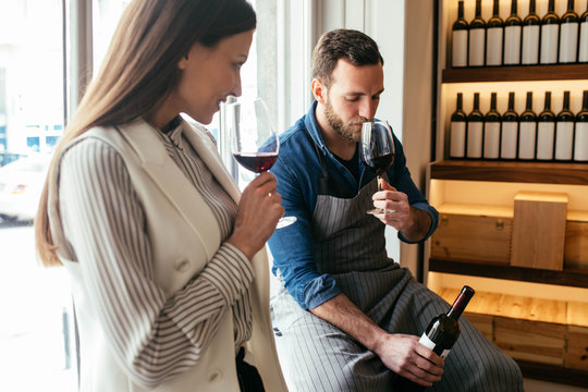 A Man and a Woman Drinking Wine at Wine Bar