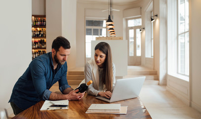 A Man and a Woman Working at Wine Bar