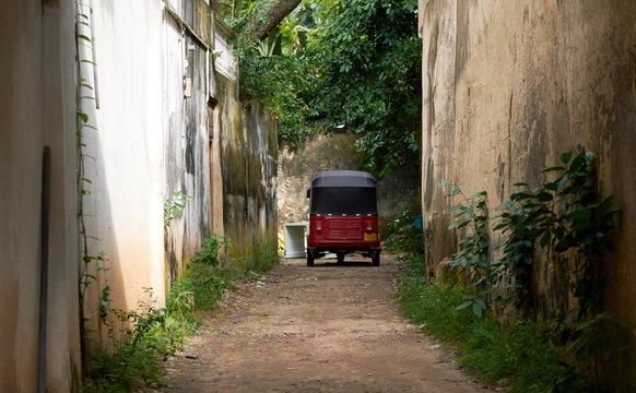 The cute red car parked in the alley. Travel in Sri Lanka