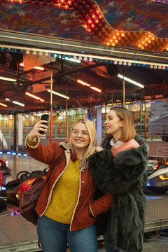 Young Women Taking Photo With Phone At The Amusement Park