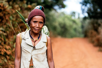 Elderly female farmer walking along road