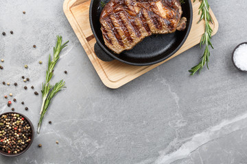 fried steak in pan on gray marble table top view