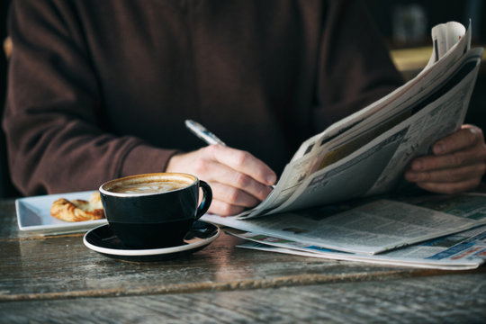 Cafe: Man Looks Through Job Listings In Newspaper