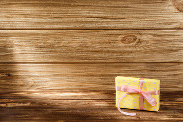 Gift box with ribbon on wooden background top view. 