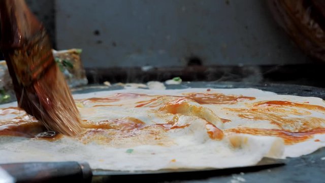 Traditional Jian Bing Being Grilled And Wrapped On Street Food. Fast Food And Cooking Concept