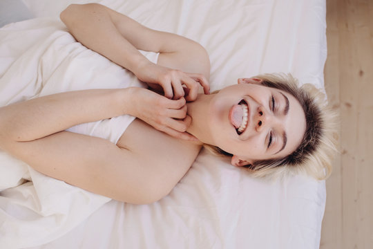 Young woman having fun in bed
