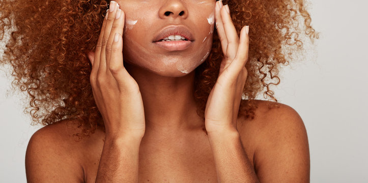 Crop skin detail woman using lotion