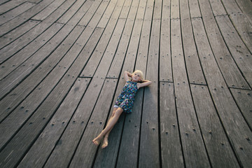 Little girl lying on wooden floor