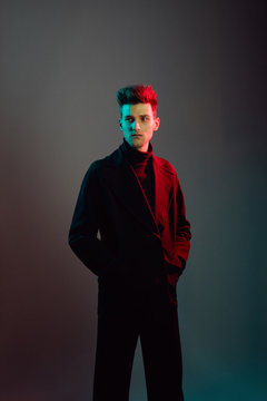 Young man wearing trench coat in studio.