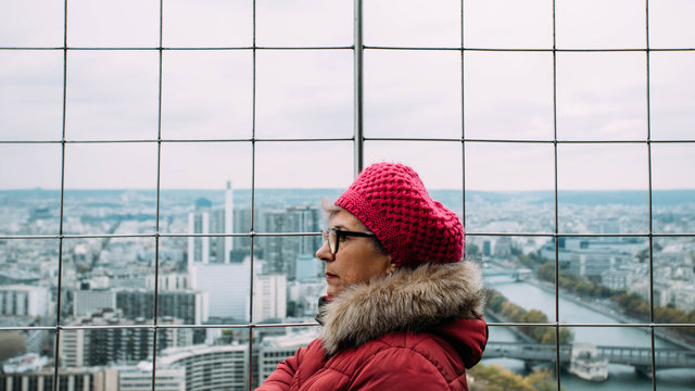 Side view of mature woman standing against cityscape
