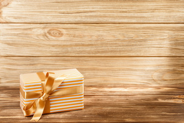 Gift box with ribbon on wooden background top view. 