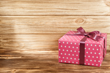Gift box with ribbon on wooden background top view. 