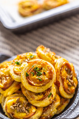 Rolls of puff pastry with ham bacon cheese sesame in dish