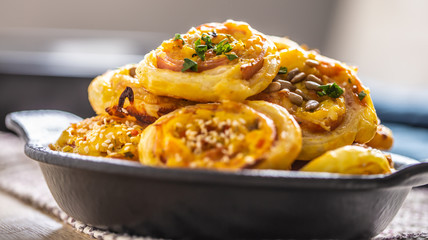 Rolls of puff pastry with ham bacon cheese sesame in dish