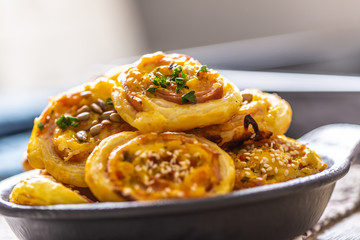 Rolls of puff pastry with ham bacon cheese sesame in dish