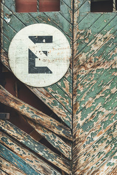 Painted sign of crossed letter on wooden door