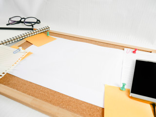 background of a wooden board, notepaper, blank paper with equipment around, such as pencils, glasses, money, mobile phones, and calendars, is a concept of financial planning, business, and work.