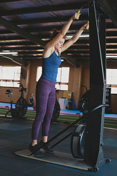 Healthy and fit, authentic woman exercising with ski machine in an indoor gym