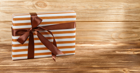 Gift box with ribbon on wooden background top view. 