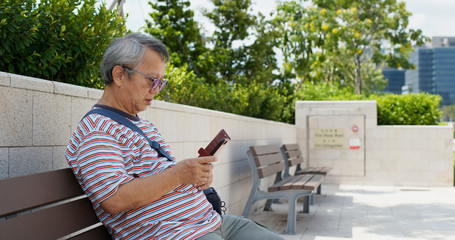 Old man use of cellphone in city