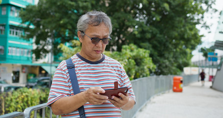 Fototapeta premium Asian old man use of mobile phone at city